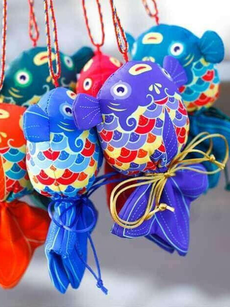 Colorful handcrafted koi fish sachets featuring intricate designs, symbolizing prosperity and offering health benefits through herbal fillings.