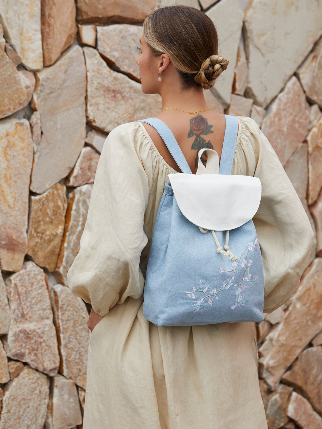 Blue canvas backpack with hand-embroidered plum blossom design, blending traditional Chinese art with modern functionality.