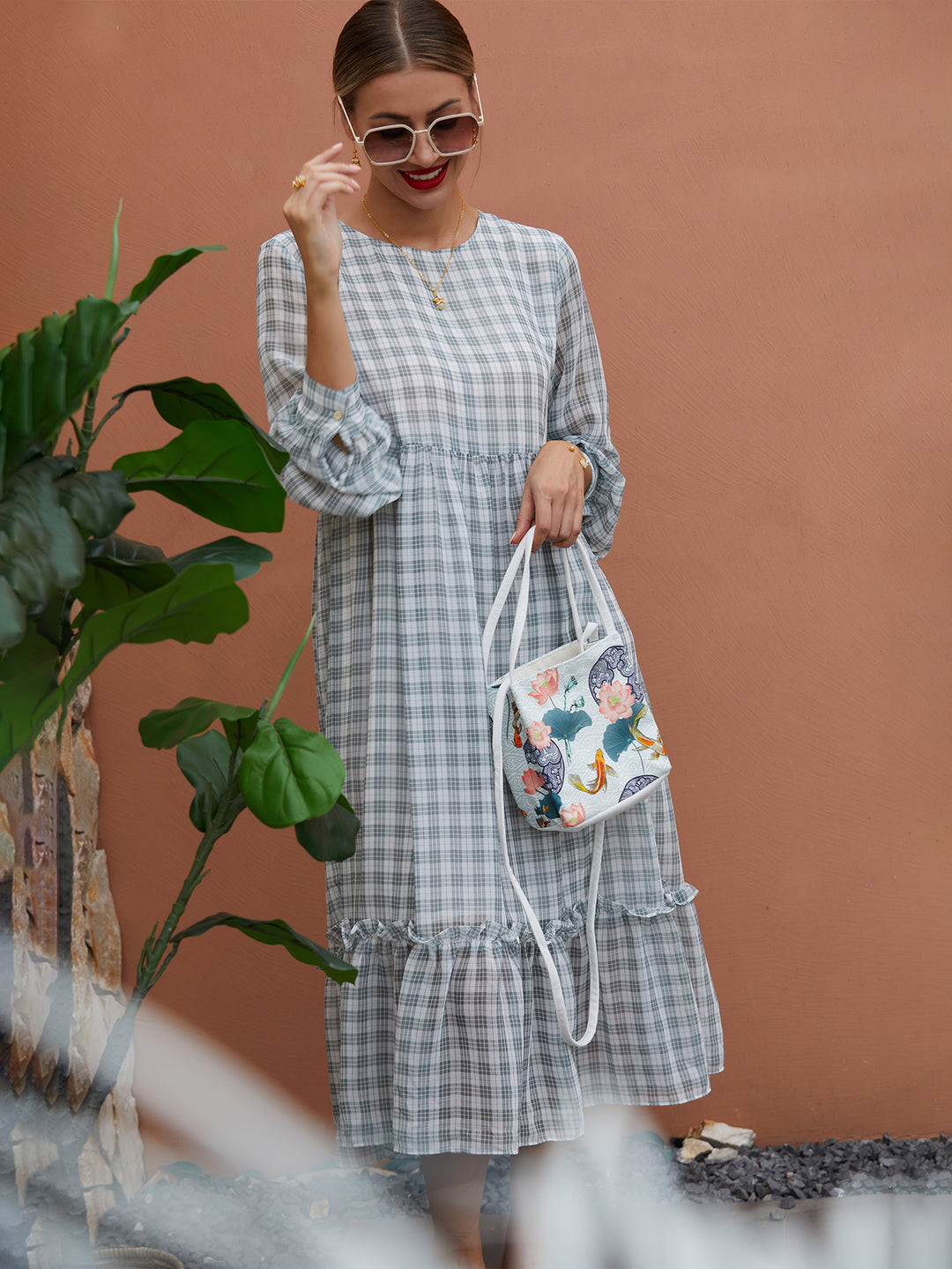 Model wearing white canvas crossbody bag with The Lotus Gatherers design, blending traditional artwork with contemporary functionality.