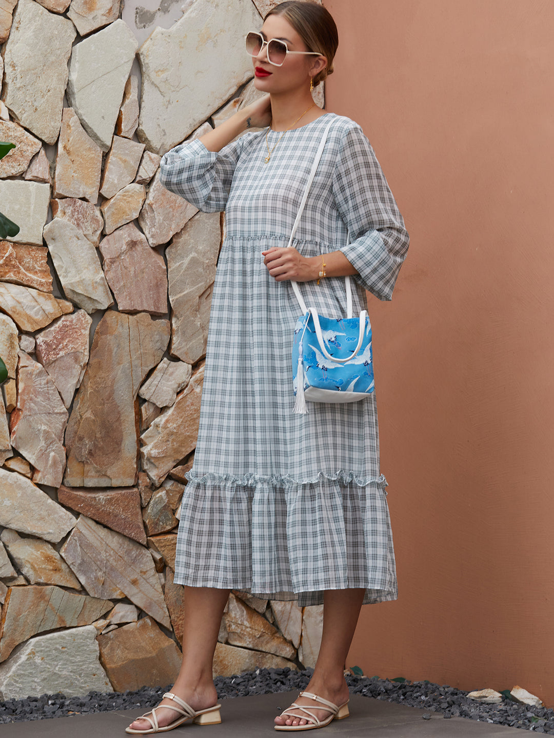 Model wearing blue canvas crossbody bag with hand-dyed crane design, blending traditional artistry with modern functionality.
