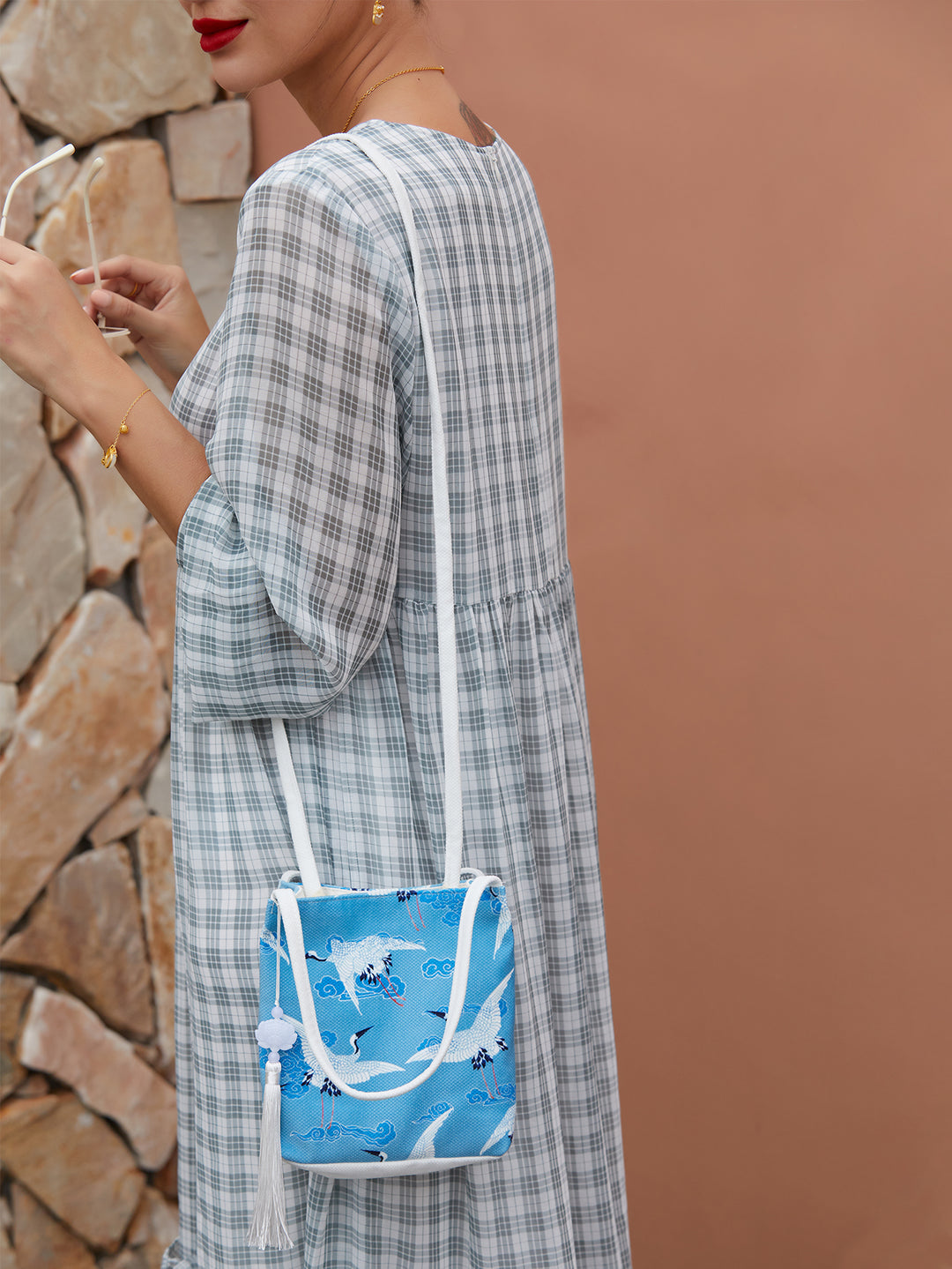 Side view of blue canvas crossbody bag with eco-friendly crane pattern, showing sleek structure and adjustable strap.