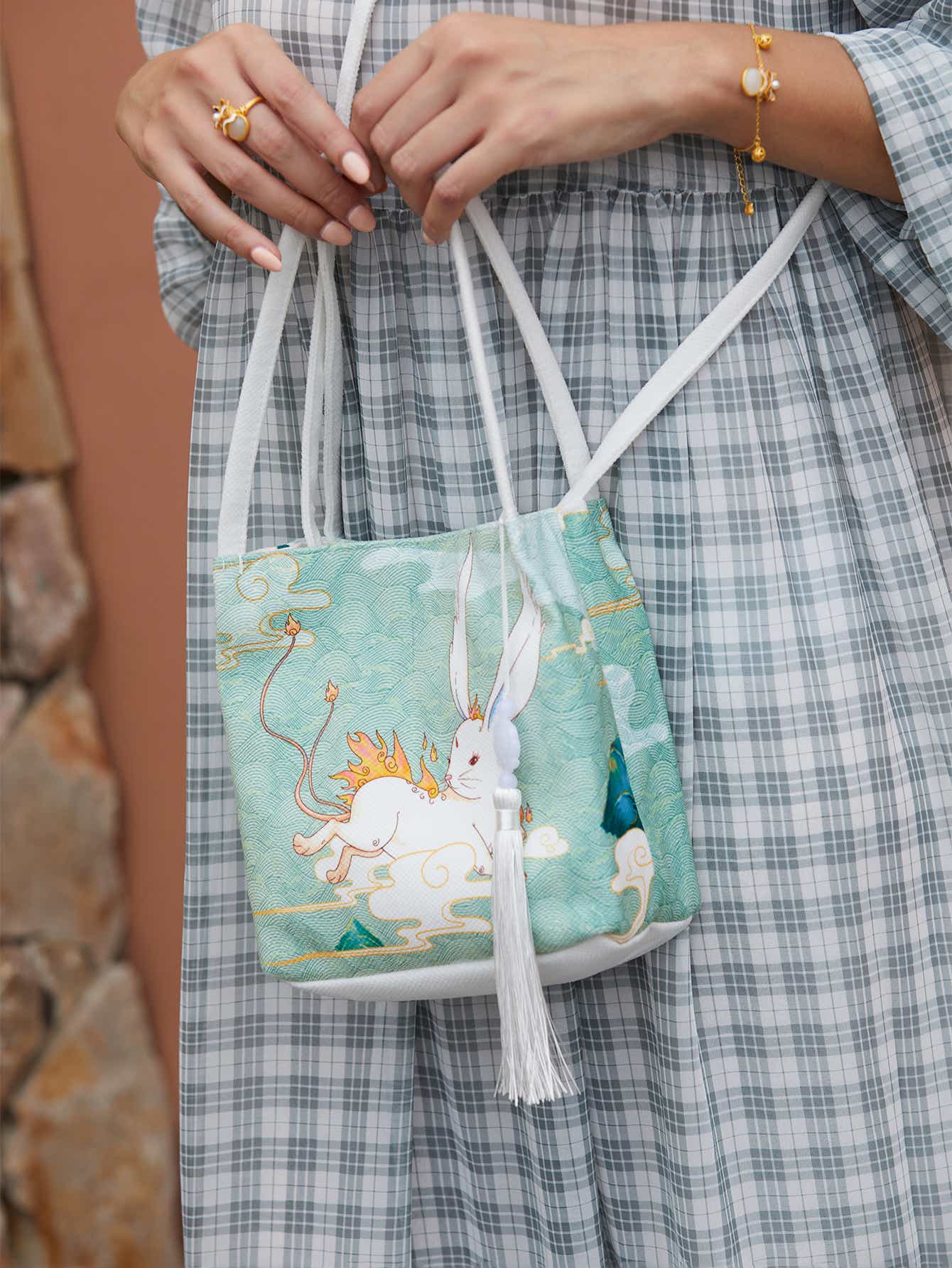 Back view of green canvas crossbody bag featuring The Jade Rabbit design, with adjustable strap and high-quality craftsmanship.