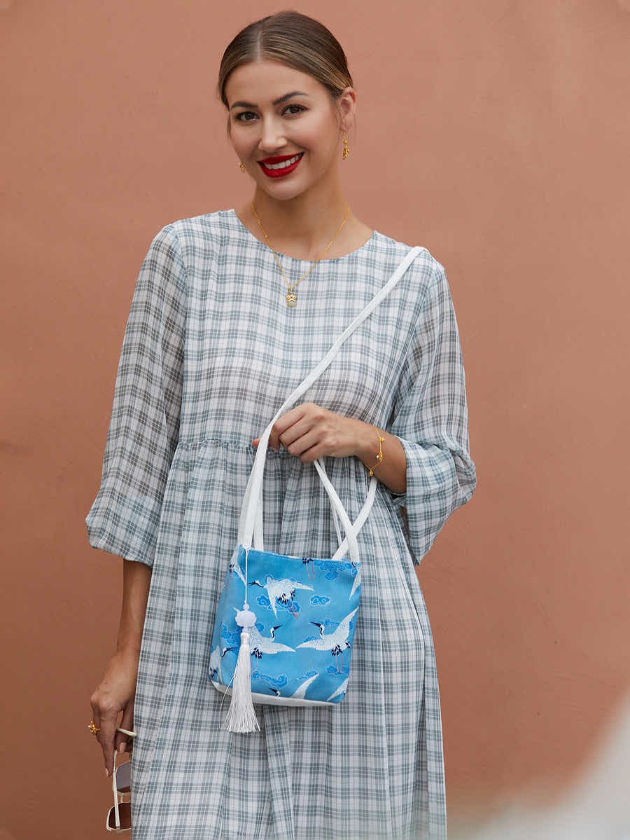 Blue canvas eco-friendly crossbody bag with hand-dyed crane pattern, combining traditional Chinese design with sustainable fashion.