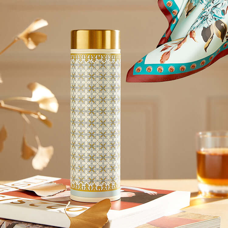 Luxurious silk scarf and thermos set with exquisite peony design on a table displaying sophistication and practicality for the modern woman.