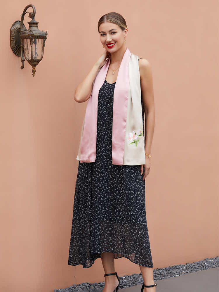 Close-up of intricate Suzhou embroidery on champagne-pink silk scarf with vibrant orange blossom design, showcasing fine craftsmanship.