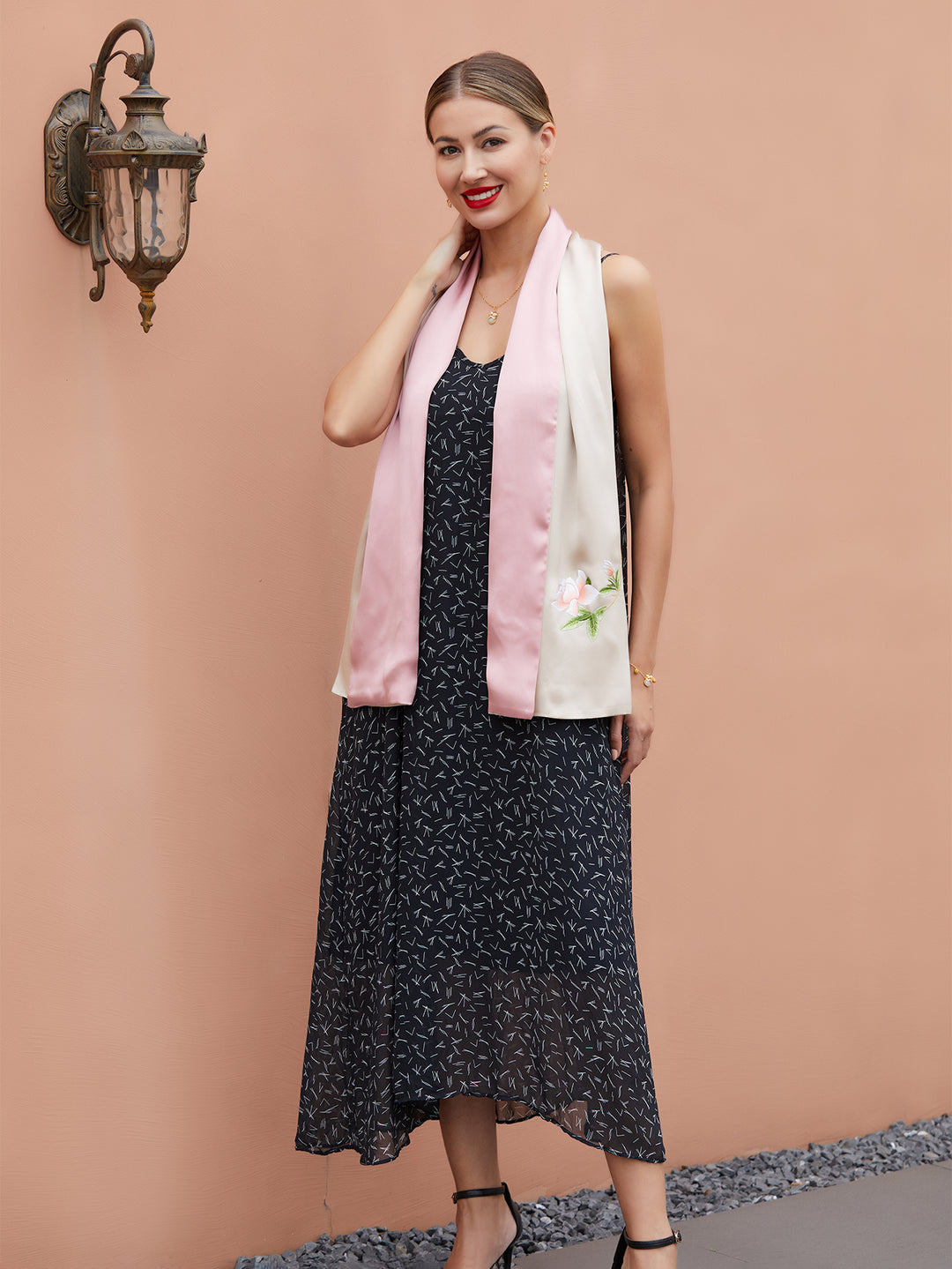 Close-up of intricate Suzhou embroidery on champagne-pink silk scarf with vibrant orange blossom design, showcasing fine craftsmanship.