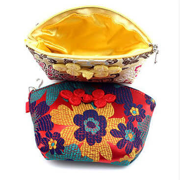 Two Silken Touch palm-sized Nanjing Brocade wallets featuring vibrant floral designs and yellow satin interiors.