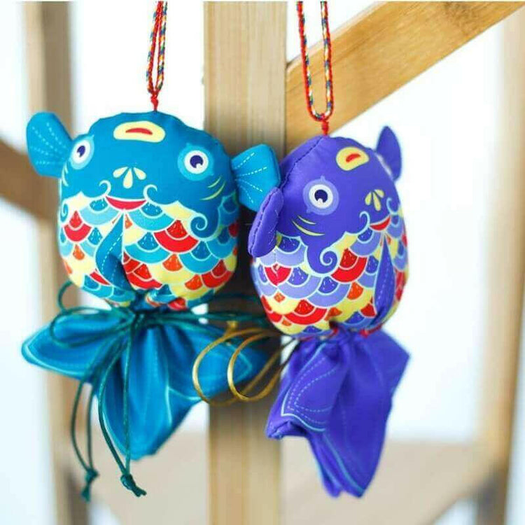 Handcrafted Koi Fish Sachets with medicinal herbs, symbolizing prosperity and success, hanging decoratively on a wooden frame