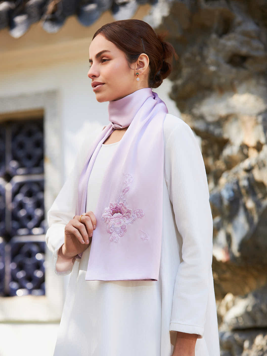Model wearing hand-embroidered pink peony silk scarf, adding elegance and cultural heritage to a sophisticated look.