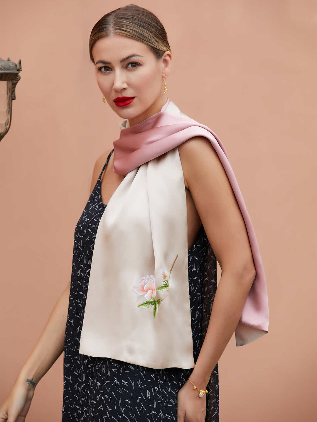 Side view of champagne-pink silk scarf adorned with vibrant orange blossom embroidery, showcasing the depth and beauty of the silk fabric.