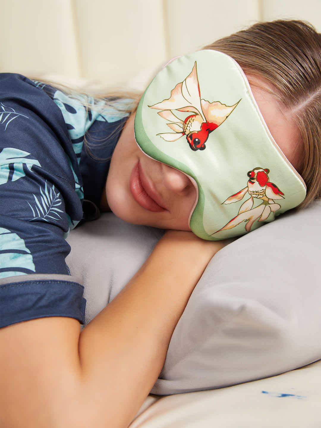 Model wearing green silk eye mask with goldfish design, showcasing its comfort and elegant Chinese-inspired design.